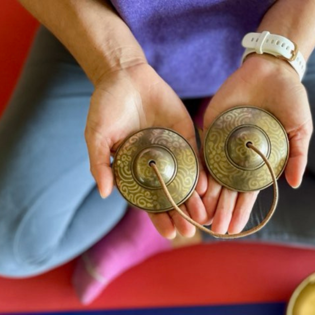 image of hands holding a pair of tingshe bells